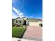 One-story house with a two-car garage, landscaping, and brick paver driveway at 17795 Blazing Star Cir, Clermont, FL 34714