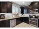 Modern kitchen with dark cabinetry, granite countertops, and stainless steel appliances at 2909 Econ Landing Blvd, Orlando, FL 32825
