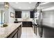 Modern kitchen with dark cabinetry, granite countertops, and stainless steel appliances at 2909 Econ Landing Blvd, Orlando, FL 32825