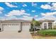 Two-story house with a three-car garage and lush landscaping at 3683 Half Moon Dr, Orlando, FL 32812