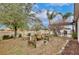 Spacious backyard with mature trees, garden area, and a patio with pergola at 431 Pheasant Dr, Haines City, FL 33844