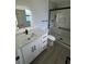 Modern bathroom with white vanity, frameless shower, and grey floors at 620 Heraldo Ct, Kissimmee, FL 34758