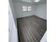 Spacious bedroom with grey wood-look floors and window with blinds at 620 Heraldo Ct, Kissimmee, FL 34758