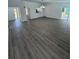 Open living area with grey wood-look floors, kitchen, and access to backyard at 620 Heraldo Ct, Kissimmee, FL 34758