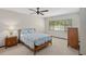 Charming bedroom featuring a floral quilt, side table with lamp, ceiling fan, and sunlit window at 654 Boniview Ln, Altamonte Springs, FL 32714