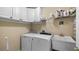 Laundry room with washer, dryer, cabinets, and utility sink at 8835 Spyglass Loop, Clermont, FL 34711