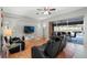 Living area with patio access, hardwood floors, and black reclining sofas at 8835 Spyglass Loop, Clermont, FL 34711