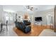 Spacious living room with hardwood floors, black reclining sofas, and a ceiling fan at 8835 Spyglass Loop, Clermont, FL 34711