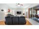 Relaxing living room with hardwood floors, black reclining sofas, and access to a patio at 8835 Spyglass Loop, Clermont, FL 34711