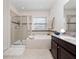 Spa-like bathroom with a soaking tub, shower, and dark wood vanity at 9218 Shepton St, Orlando, FL 32825