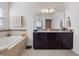 Elegant bathroom with a soaking tub, double vanity, and dark wood cabinets at 9218 Shepton St, Orlando, FL 32825