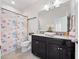 Bathroom with shower/tub combo, dark vanity, and seashell shower curtain at 9218 Shepton St, Orlando, FL 32825