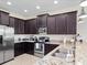Spacious kitchen with dark wood cabinets, granite countertops, and stainless steel appliances at 9218 Shepton St, Orlando, FL 32825