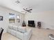 Living room with light gray sofa, ceiling fan, and large TV at 9218 Shepton St, Orlando, FL 32825