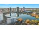 Aerial view of downtown skyline and lake with boaters under a partly cloudy blue sky at 100 S Eola Dr # 1405, Orlando, FL 32801