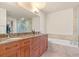 Modern bathroom featuring double sinks with granite countertops, a soaking tub, and glass-enclosed shower at 100 S Eola Dr # 1405, Orlando, FL 32801