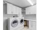 Functional laundry room with white cabinets, countertops, washer, and dryer at 100 S Eola Dr # 1405, Orlando, FL 32801