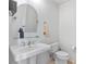 Elegant powder room with pedestal sink, arched mirror, and chrome fixtures at 100 S Eola Dr # 1405, Orlando, FL 32801