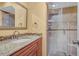 Bathroom with granite countertop, wood vanity, and shower at 1007 Baseball And Boardwalk Ct, Kissimmee, FL 34746