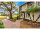 Exterior side view of the townhome with lush landscaping, a brick walkway, and mature trees at 1007 Baseball And Boardwalk Ct, Kissimmee, FL 34746