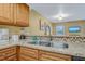 Kitchen with double sink, granite countertop and wood cabinets at 1007 Baseball And Boardwalk Ct, Kissimmee, FL 34746