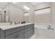 Spa-like bathroom with double vanity, soaking tub and grey cabinetry at 1038 Jack Nicklaus Ct, Kissimmee, FL 34747