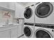 Bright laundry room with stacked washer and dryer, cabinets and a sink at 1038 Jack Nicklaus Ct, Kissimmee, FL 34747