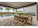 Covered patio with large dining table and pool view at 1038 Jack Nicklaus Ct, Kissimmee, FL 34747