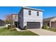 Two-story house with gray siding, two-car garage, and landscaping at 1101 Atlantic Ave, Fruitland Park, FL 34731