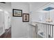 Upstairs hallway with hardwood floors and framed artwork at 1101 Atlantic Ave, Fruitland Park, FL 34731