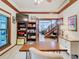 Home office with built-in shelving, hardwood floors, and a view into the living area at 1105 Superior Ct, Winter Springs, FL 32708