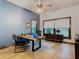 Bright home office with a large wood desk, ceiling fan, and blue accent wall at 1105 Superior Ct, Winter Springs, FL 32708