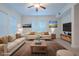 Virtually staged living room with beige sofas and a coffee table at 1410 Celebration Ave # 101, Celebration, FL 34747