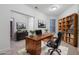 Virtually staged home office with a large desk and built-in shelving at 1410 Celebration Ave # 101, Celebration, FL 34747