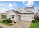 Two-story white house with gray roof, three-car garage, and landscaped front yard at 14255 Spring Garden Dr, Winter Garden, FL 34787