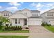 Two story home with white exterior, three car garage, and manicured landscaping at 14255 Spring Garden Dr, Winter Garden, FL 34787