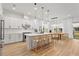 Modern white kitchen with center island, stainless steel appliances, and hardwood floors at 14255 Spring Garden Dr, Winter Garden, FL 34787