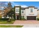 Two-story house with a white exterior, brown garage door, and a brick driveway at 16669 Varone Cove Ct, Winter Garden, FL 34787