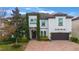 Two-story house with a white exterior, brown garage door, and a brick driveway at 16669 Varone Cove Ct, Winter Garden, FL 34787