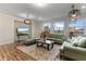 Living area with hardwood floors, sofas, and large windows offering natural light at 16669 Varone Cove Ct, Winter Garden, FL 34787