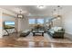 Living area with hardwood floors, sofas, and large windows offering natural light at 16669 Varone Cove Ct, Winter Garden, FL 34787