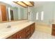 Double vanity bathroom with a bathtub and wood cabinets at 214 Covent Garden Ave, Davenport, FL 33897