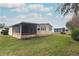 Tan mobile home with screened porch and spacious lawn at 214 Covent Garden Ave, Davenport, FL 33897