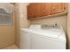 Laundry room with washer, dryer, and wood cabinets at 214 Covent Garden Ave, Davenport, FL 33897