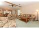 Living room with floral couches, coffee table, and view into dining area at 214 Covent Garden Ave, Davenport, FL 33897