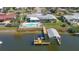 An aerial view of a waterfront home with a boat dock featuring a covered lift and a swimming pool at 218 S Venetian Way, Port Orange, FL 32127