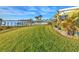 Waterfront backyard featuring lush green grass, a pool, and beautiful canal views at 218 S Venetian Way, Port Orange, FL 32127