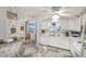 Functional kitchen featuring white cabinetry, appliances, adjacent dining space, and pleasant floral wallpaper, creating a cozy atmosphere at 218 S Venetian Way, Port Orange, FL 32127