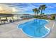 Outdoor pool is kidney-shaped, complemented by palm trees and a dock overlooking a serene waterfront at 218 S Venetian Way, Port Orange, FL 32127