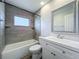 Updated bathroom with gray tile, white vanity, and a bathtub at 2207 Winter Woods Blvd, Winter Park, FL 32792